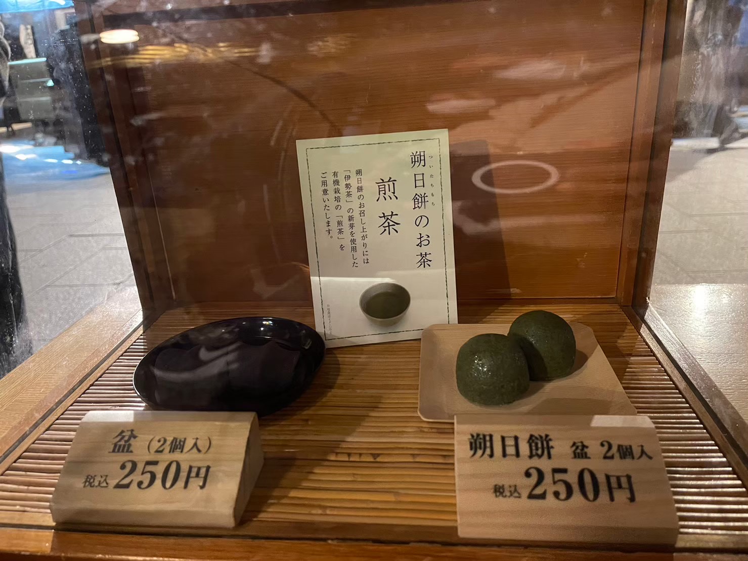 赤福本店の店頭に並ぶ朔日餅「盆2個入 税込250円」の見本と伊勢茶の案内