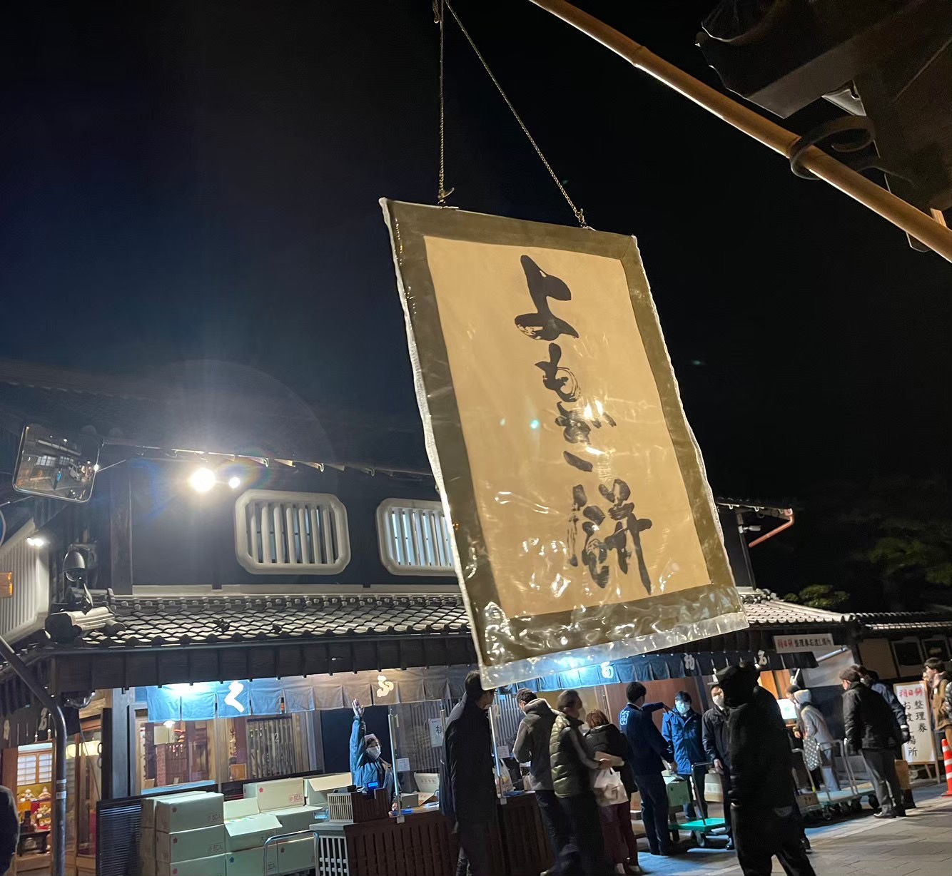 早朝の赤福本店に掲げられた「よもぎ餅」の看板と、朔日餅を待つ人たち